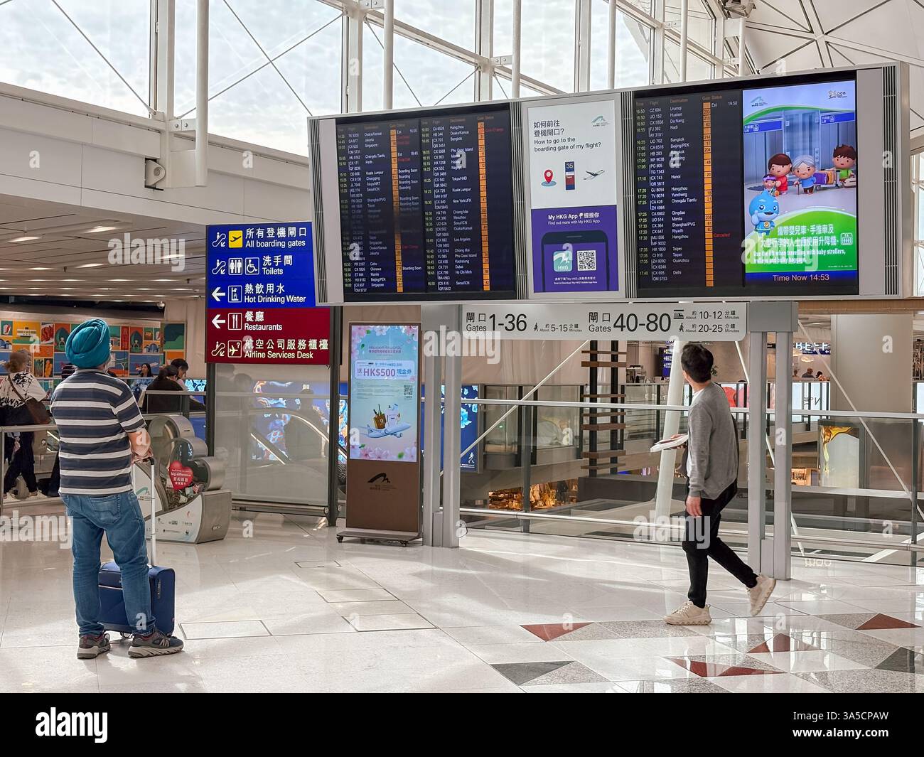 Passagiere, die die Fluginformationen am Hong Kong International Airport überprüfen. Reise- und Transportbranche. Stockfoto