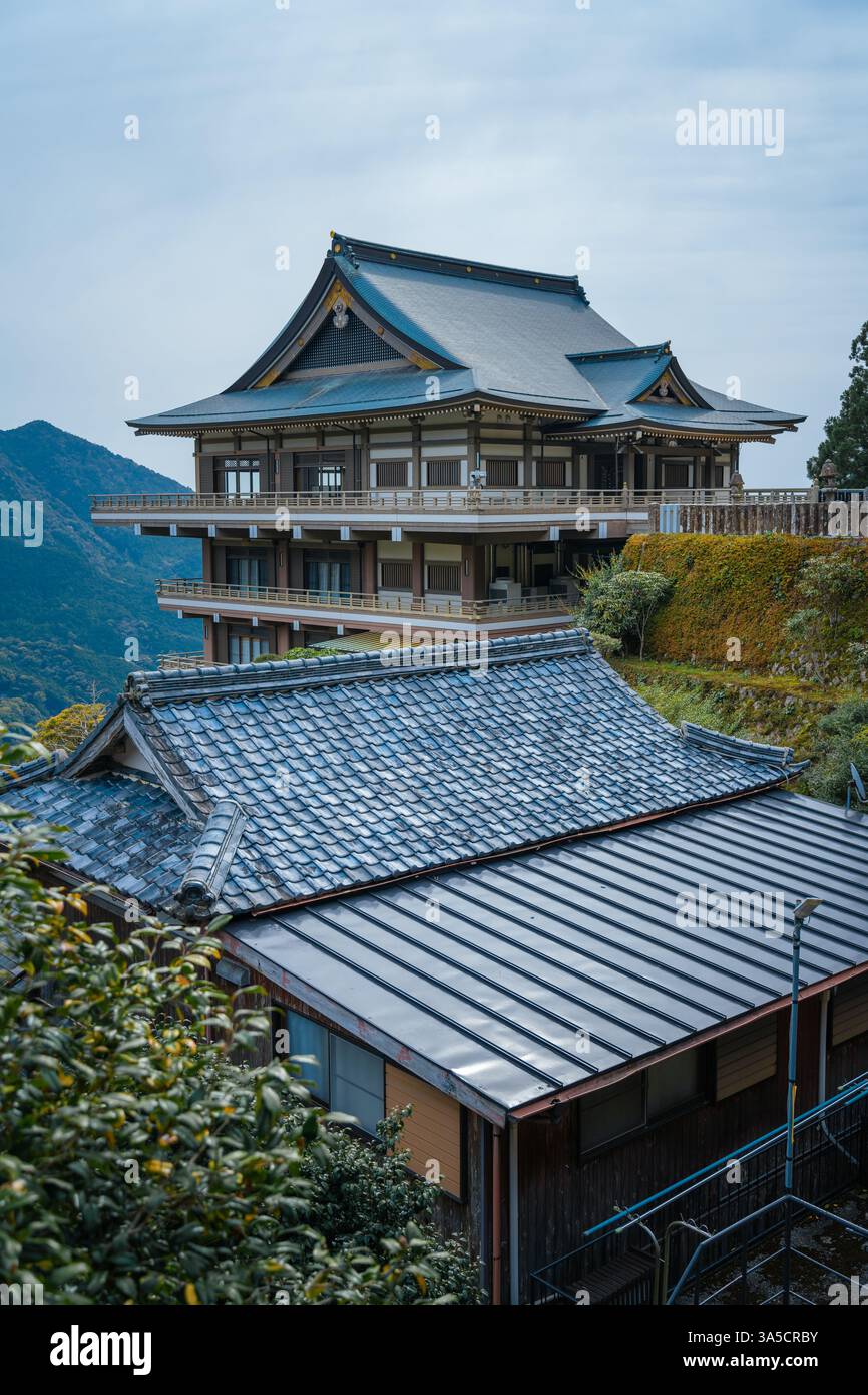 Atemberaubende Nachi-Fälle und Seiganto-JI-Tempel eingerahmt von Kirschblüten – Ein zeitloses Symbol für Japans natürliche Schönheit und spirituelles Erbe! Stockfoto