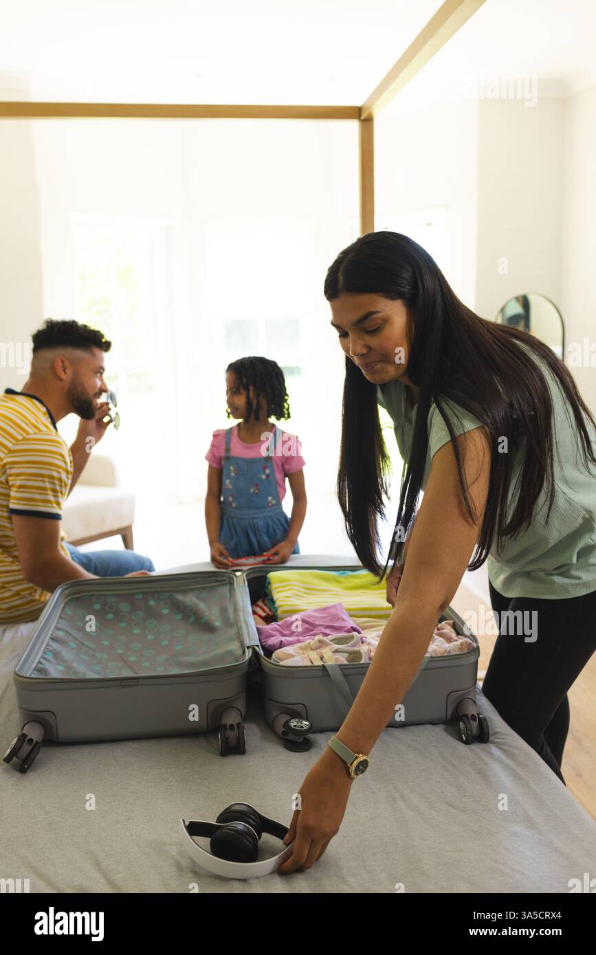 Familie packt Koffer zu Hause und bereitet sich mit Aufregung und Lächeln auf den Urlaub vor Stockfoto