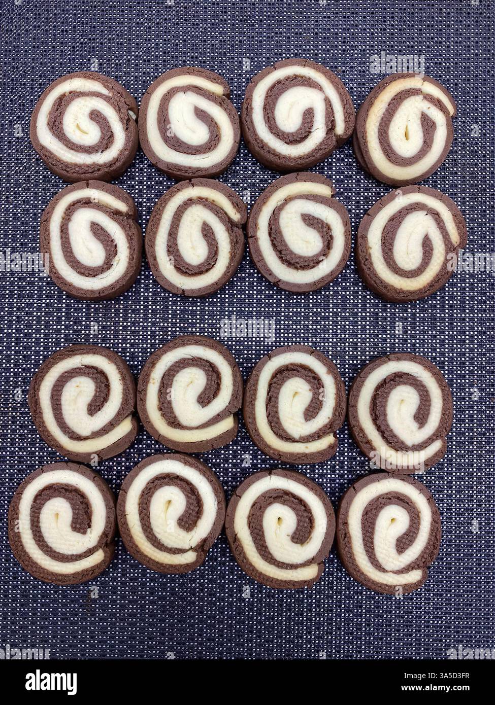Kreisförmige Kekse sind perfekt in Reihen angeordnet und zeigen eine herrliche Kombination aus Schokolade und Vanille. Stockfoto