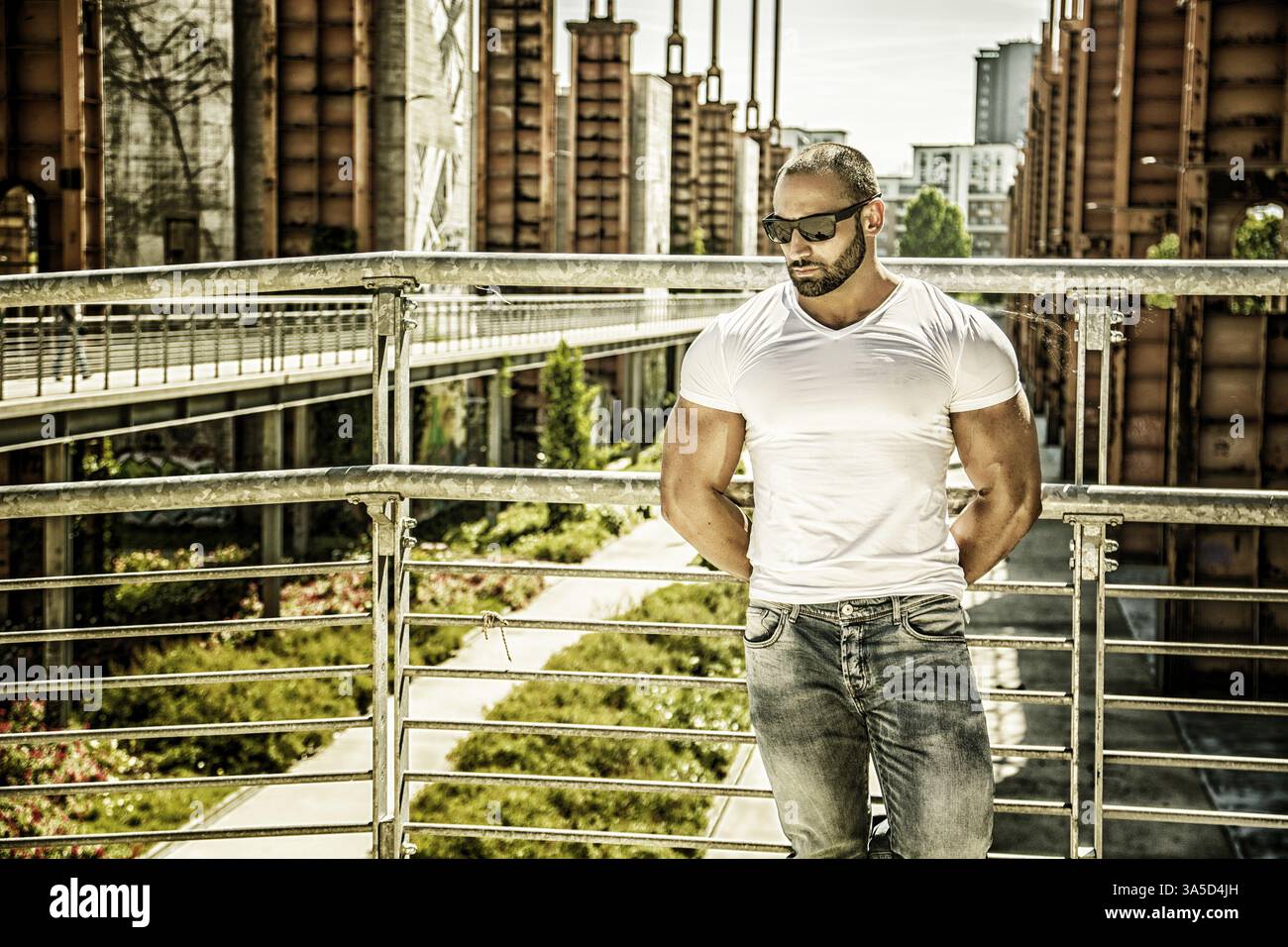 Gut aussehend muskulösen blonden Mann stehend in städtischen Umgebung oder ehemaligen industriellen Umfeld Stockfoto