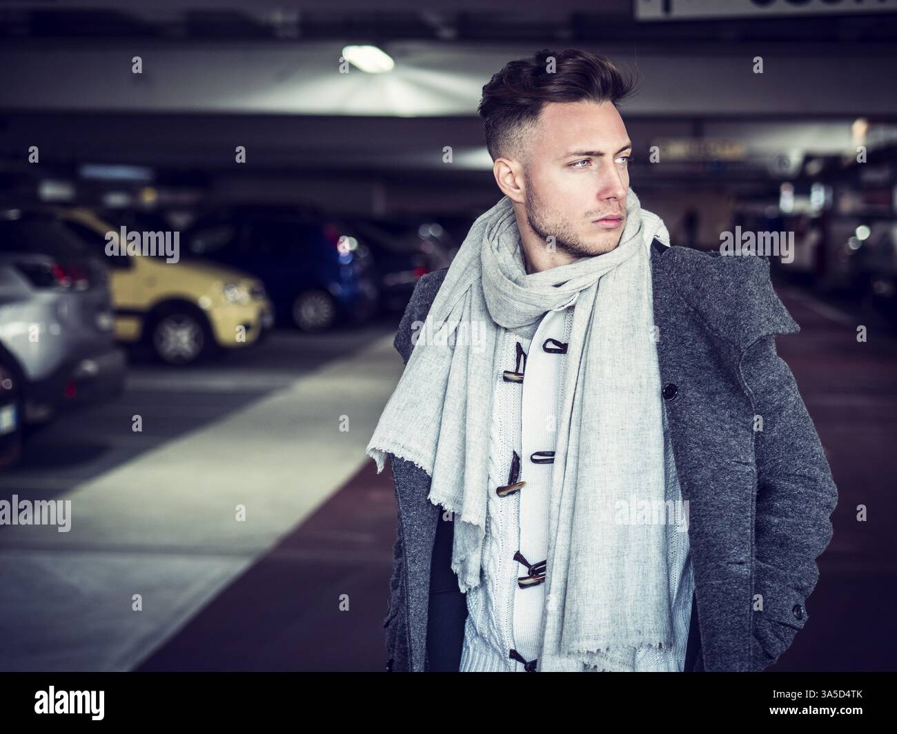 Schöner Mann in Freizeitkleidung auf dem Hintergrund von Indoor Parkplatz Stockfoto