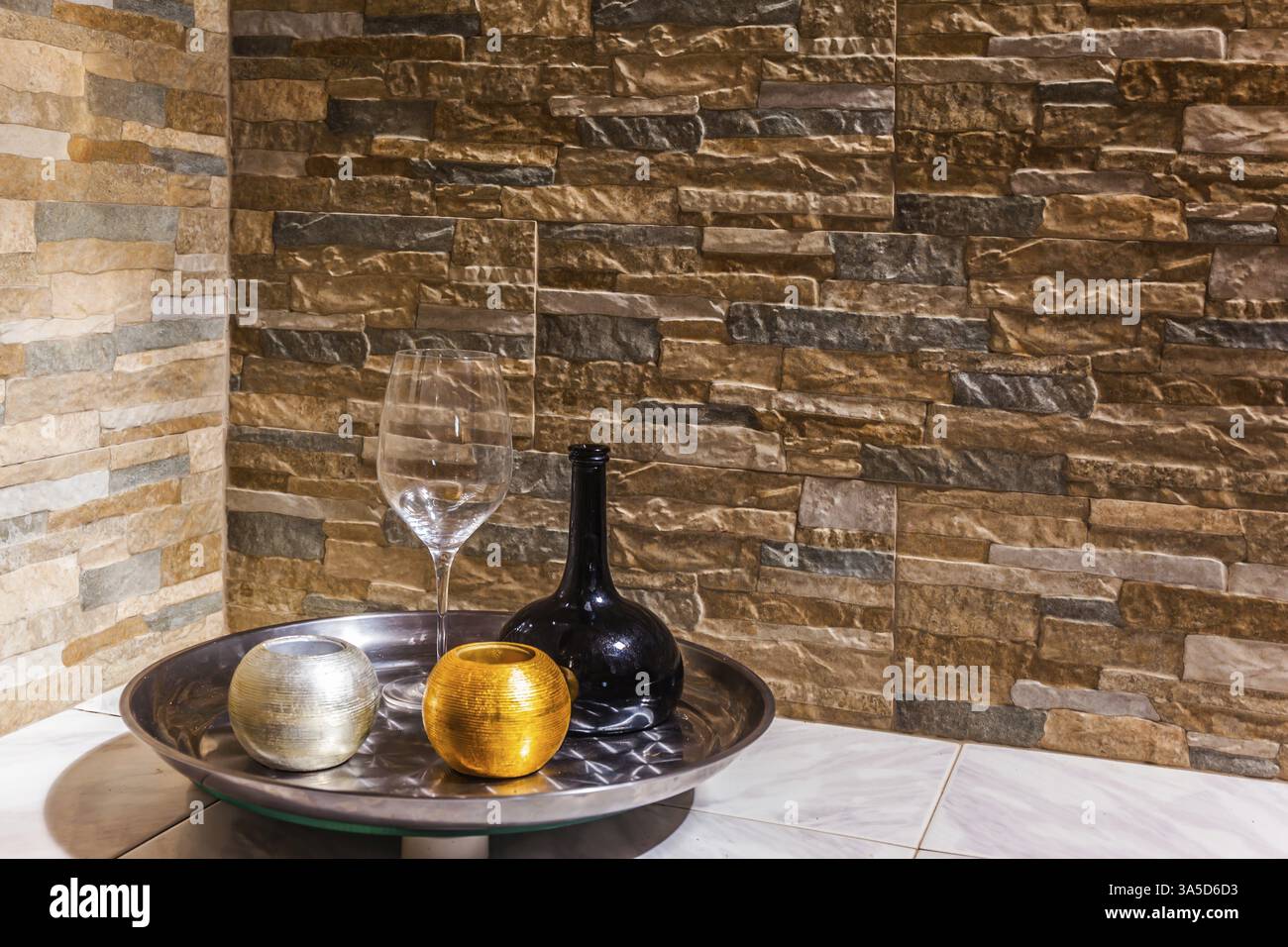 Stillleben mit einer schwarzen Glaskanne, einem transparenten Glas und zwei Kerzenleuchtern. Steinmauer im Hintergrund. Das Konzept der künstlerischen Fotografie Stockfoto Stillleben mit einer schwarzen Glaskanne, einem transparenten Glas und zwei Kerzenleuchtern. Steinmauer im Hintergrund. Das Konzept der künstlerischen Fotografie Stockfoto