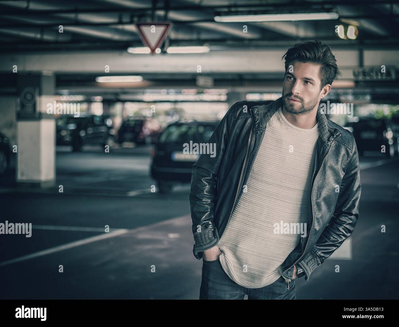 Gutaussehender muskulöser Mann in lässiger Kleidung vor dem Hintergrund des Parkens Stockfoto