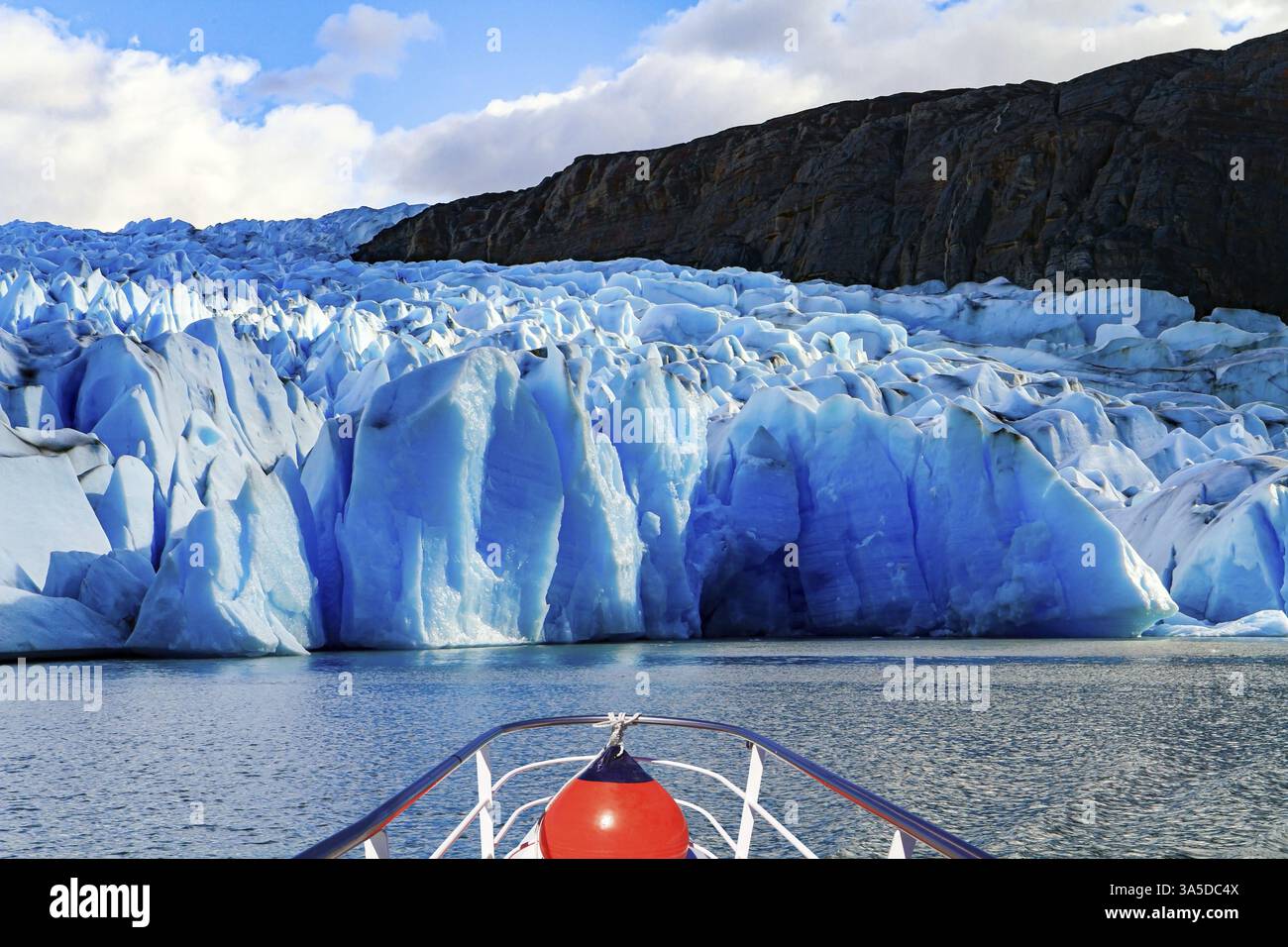 Der Graugletscher ist Teil des Südpatagonischen Eisfeldes. Der Gray Glacier ist der drittgrößte der Welt. Boot mit Touristen schwimmt zwischen Eisbergen Stockfoto