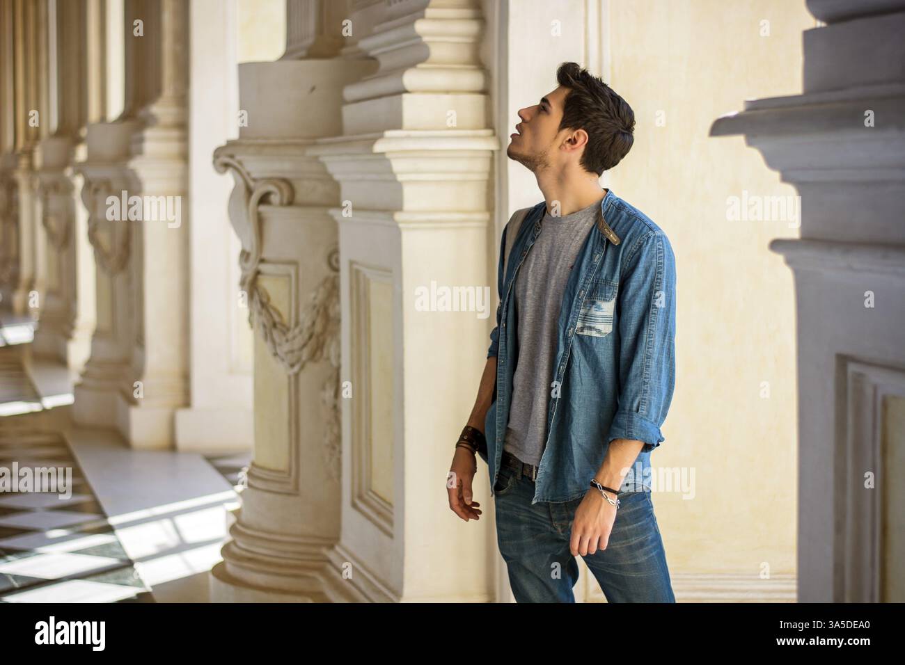 Eine halbe Stelle erschossen von nachdenklich hübscher junger Mann wegsehen in einem Museum Stockfoto