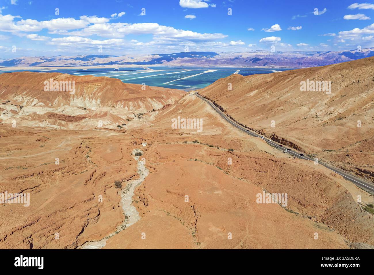 Judäische Wüste am Ufer des Toten Meeres. Trockene, wasserlose Hügel aus beigem Ton. Ausgezeichnete Straßen liegen zwischen den Hügeln. Die Fotos wurden von einem gemacht Stockfoto