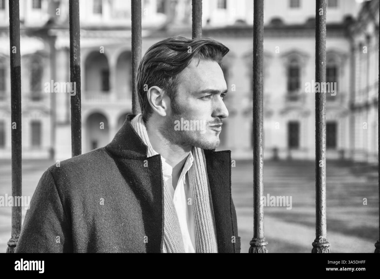 Taille, der stilvolle junge Mann tragen Fell und Looking Up vor historischen Gebäude im Hintergrund Stockfoto