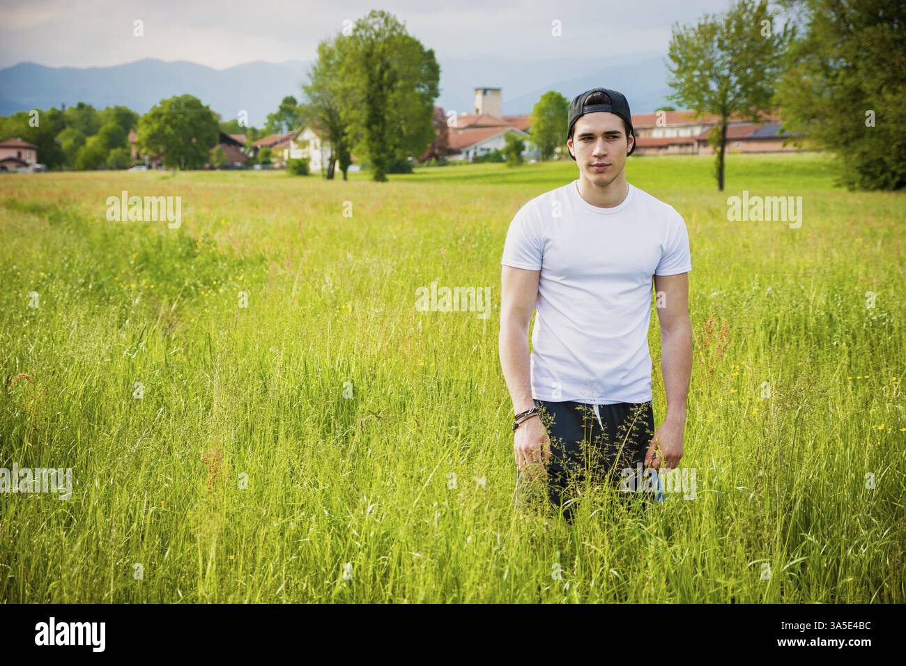 Schön Fit Jüngling am Land, im Feld oder Wiese, tragen weiße T-shirt und Mütze, Blick in die Kamera Stockfoto
