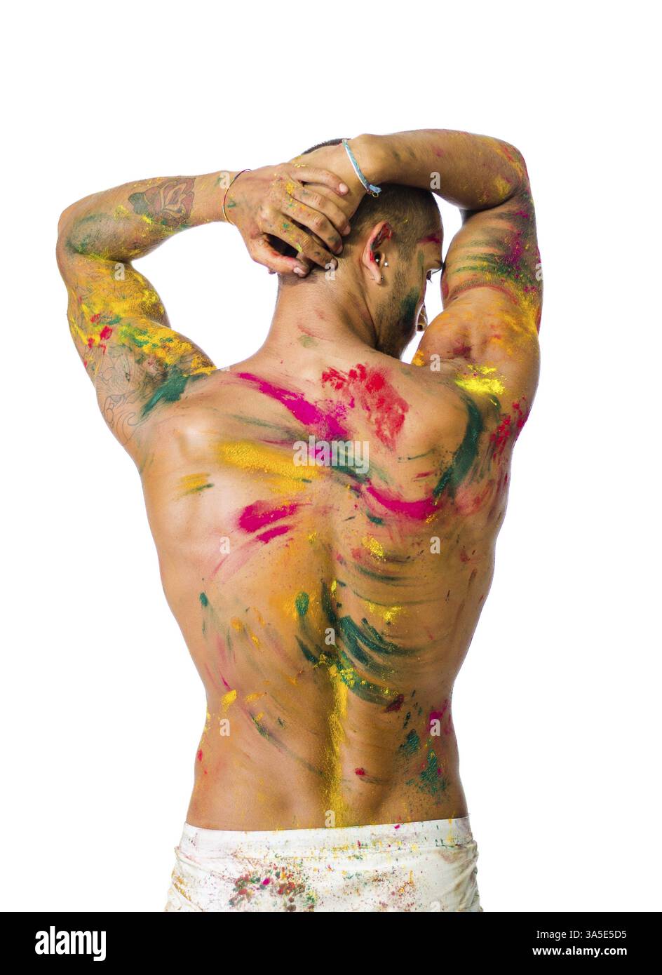 Hübscher junger Mann von hinten mit Haut alle gesehen mit Holi Farben, isoliert auf weißem Hintergrund gemalt Stockfoto