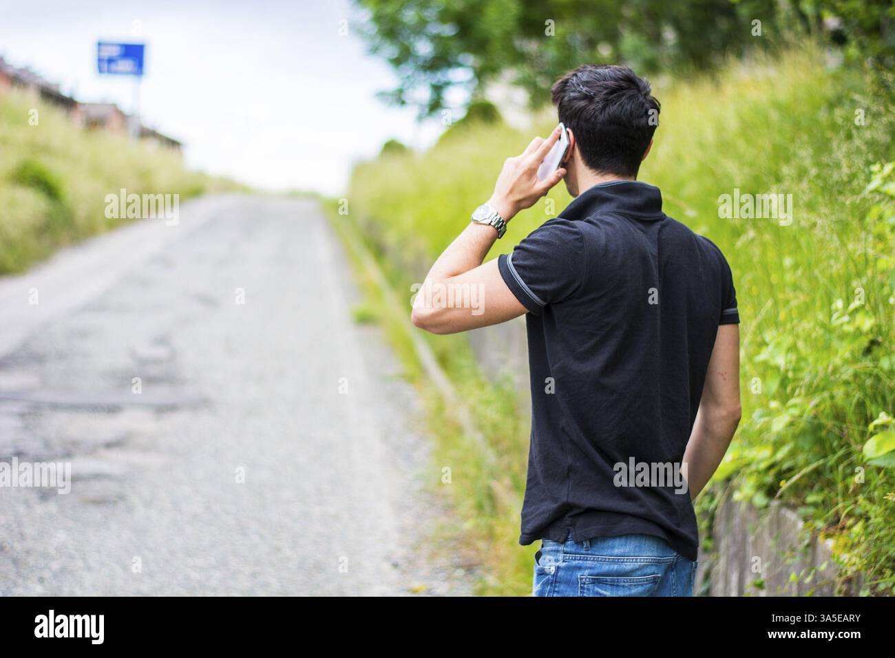Schönen jungen Mann auf einer Straßenseite anrufen auf Handy und warten für Taxi Taxi Stockfoto