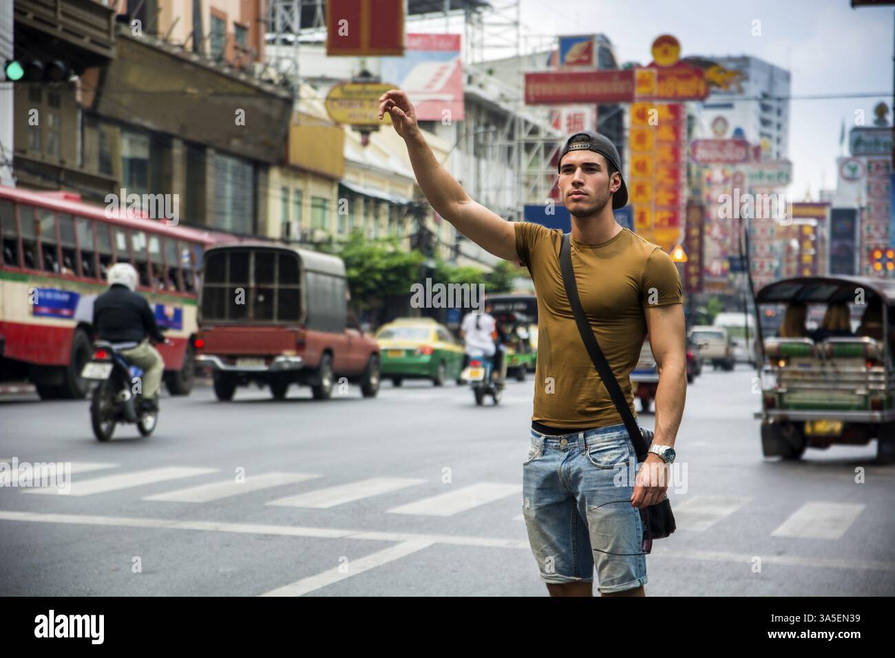 Mann mit Hand auf der Straße stehend in Bangkok, Thailand. Horizontal im Freien gedreht Stockfoto