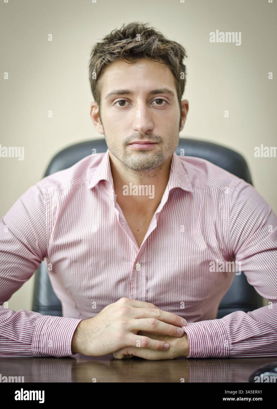 Ernst, attraktive junge Büroangestellte im Hemd an seinem Schreibtisch, Blick in die Kamera Stockfoto Ernst, attraktive junge Büroangestellte im Hemd an seinem Schreibtisch, Blick in die Kamera Stockfoto