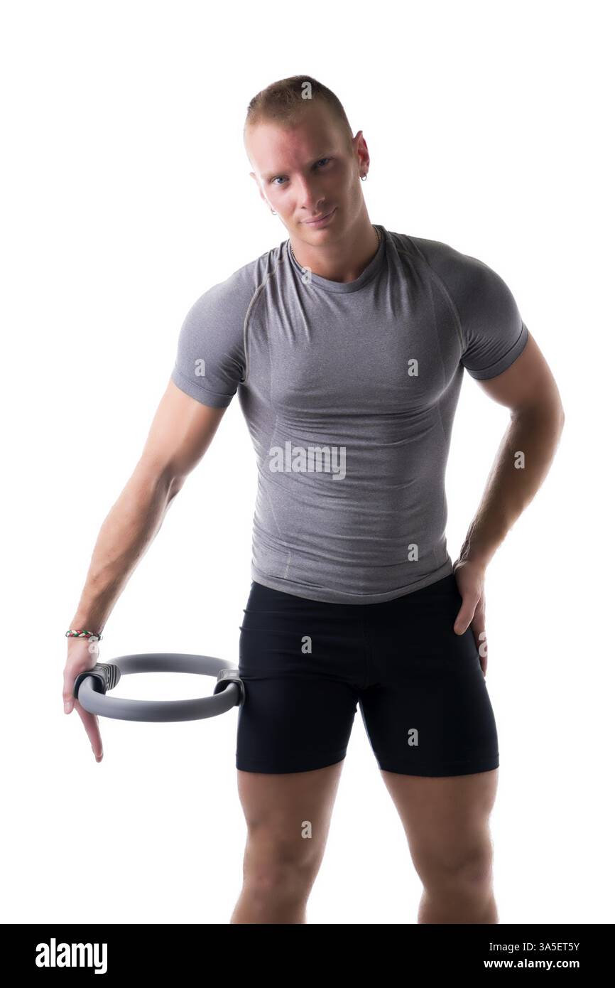 Jungen muskulösen Mann Training mit Pilates Ring gegen Oberschenkel, isoliert auf weiss Stockfoto