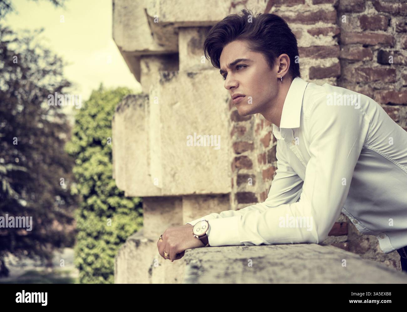 Ein hübscher, eleganter junger Mann in einer Stadt in Europa, der an sonnigen Tagen steht Stockfoto