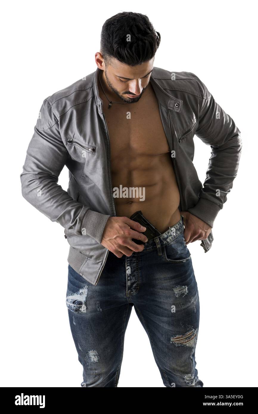 Halbkörperschuss eines gutaussehenden Athletikers ohne Hemd mit einer Pistole in der Hose, während er nach unten blickt. Isoliert auf weißem Hintergrund Stockfoto