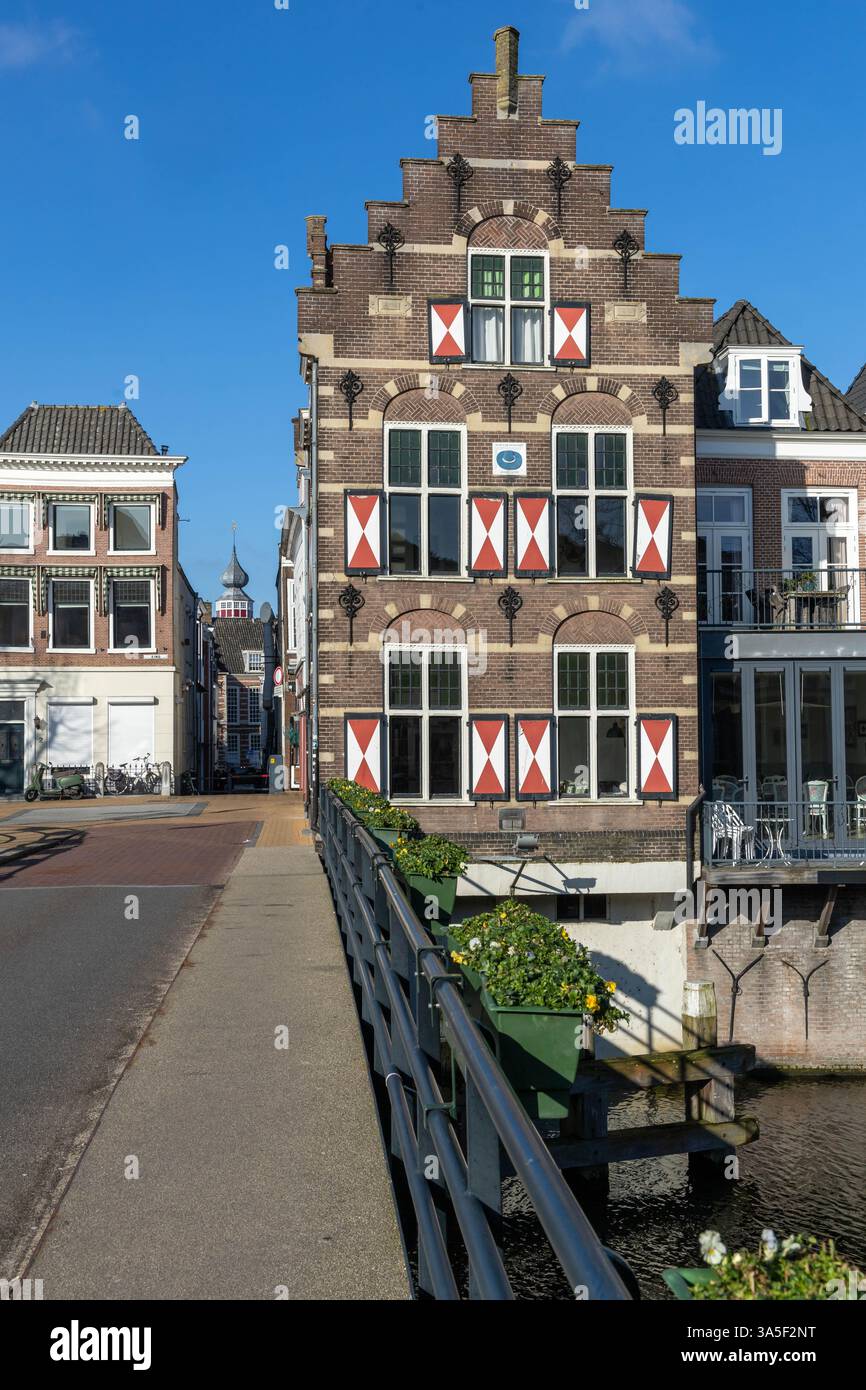 Typische Häuser mit rot-weißen Fensterläden in der befestigten Stadt Gorinchem entlang der Brücke und des Kanals Linge. Stockfoto