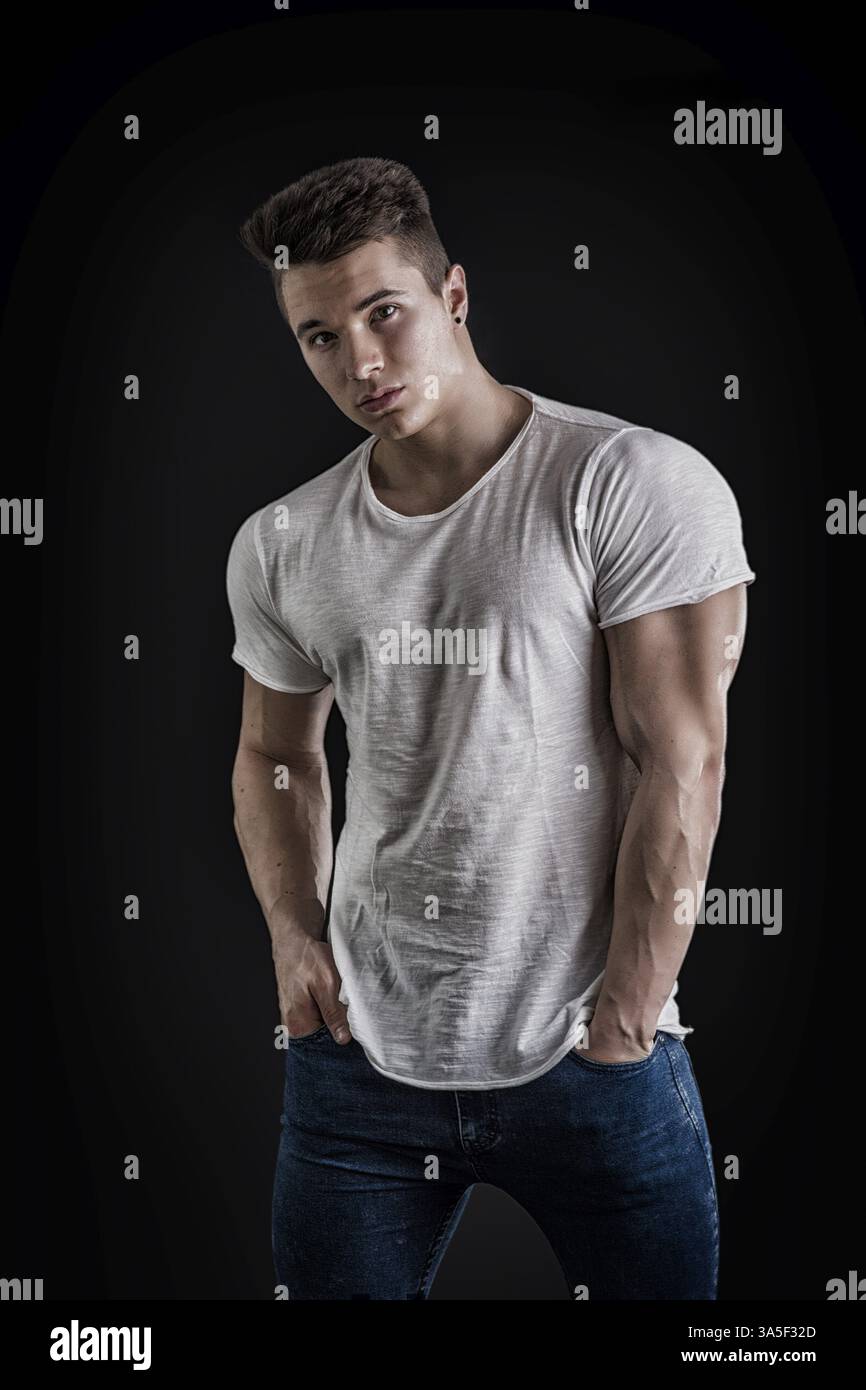 Hübscher junger muskulöser Mann, der die Kamera im Studio ansieht Über neutralen Hintergrund Stockfoto