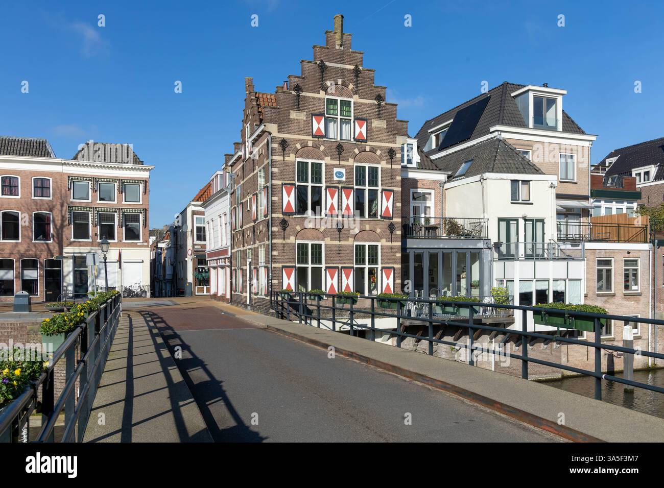Typische Häuser mit rot-weißen Fensterläden in der befestigten Stadt Gorinchem entlang der Brücke und des Kanals Linge. Stockfoto
