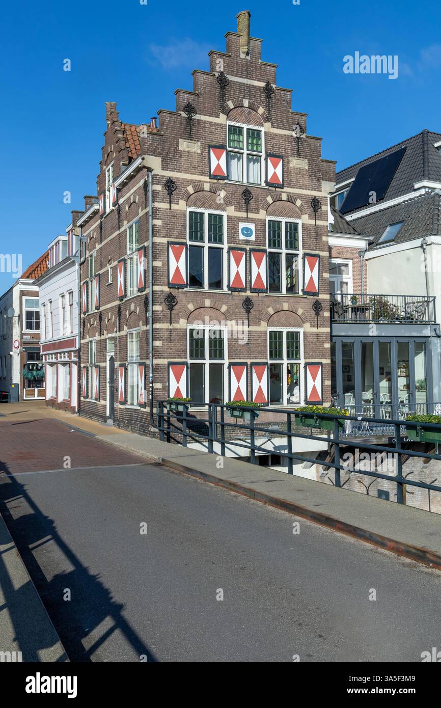 Typische Häuser mit rot-weißen Fensterläden in der befestigten Stadt Gorinchem entlang der Brücke und des Kanals Linge. Stockfoto