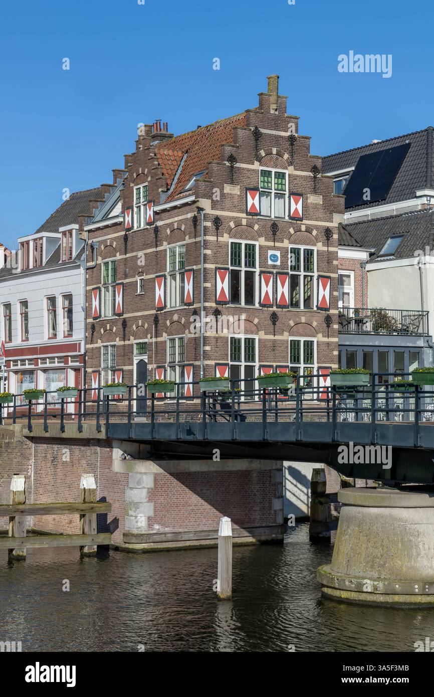 Typische Häuser mit rot-weißen Fensterläden in der befestigten Stadt Gorinchem entlang der Brücke und des Kanals Linge. Stockfoto