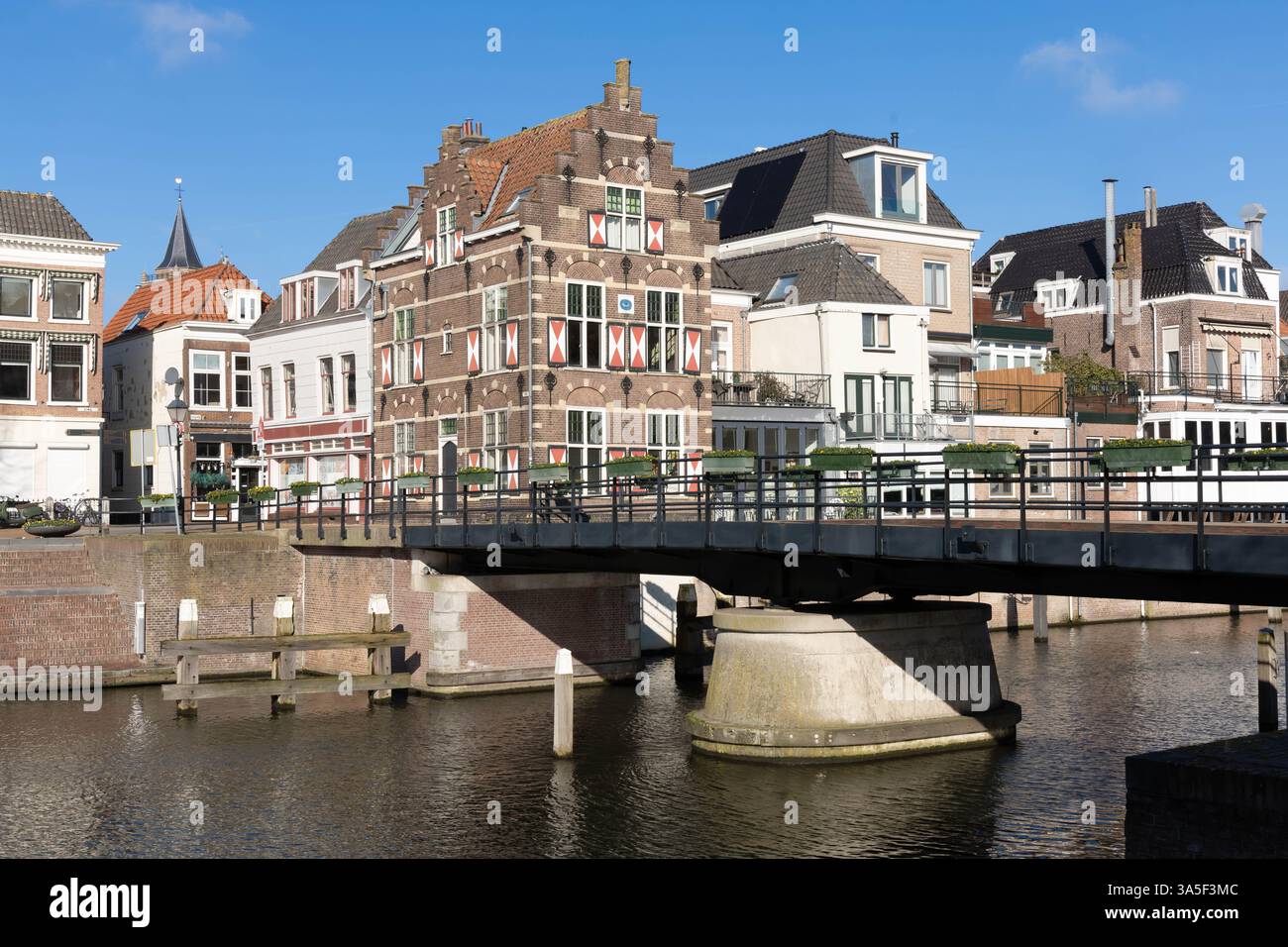 Typische Häuser mit rot-weißen Fensterläden in der befestigten Stadt Gorinchem entlang der Brücke und des Kanals Linge. Stockfoto