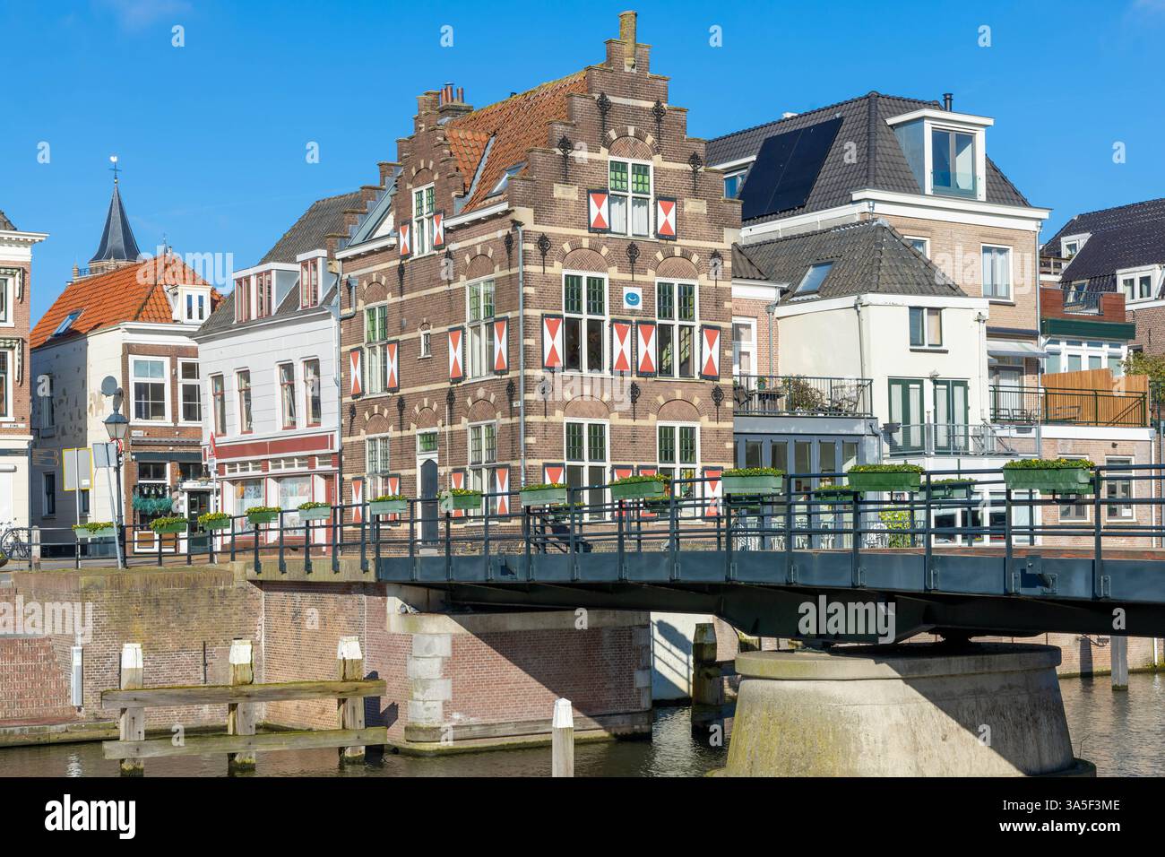 Typische Häuser mit rot-weißen Fensterläden in der befestigten Stadt Gorinchem entlang der Brücke und des Kanals Linge. Stockfoto