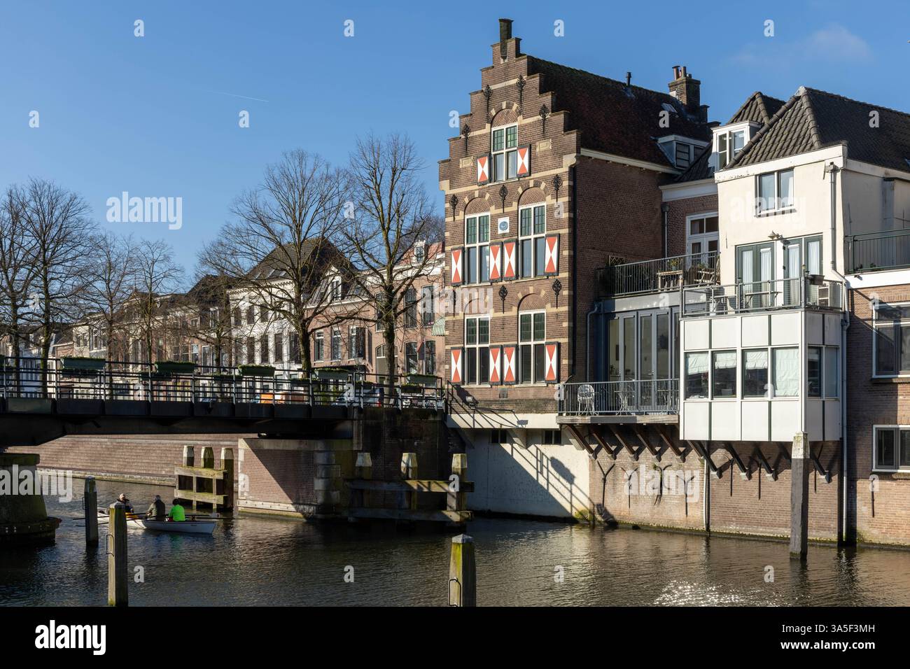 Typische Häuser mit rot-weißen Fensterläden in der befestigten Stadt Gorinchem entlang der Brücke und des Kanals Linge. Stockfoto