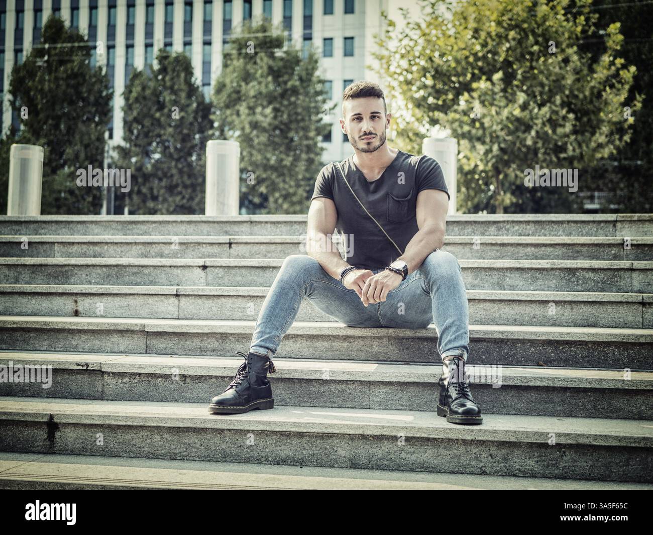Ein hübscher junger Mann im städtischen Umfeld in der Europäischen Stadt, in Jeans und T-Shirt schwarz Stockfoto