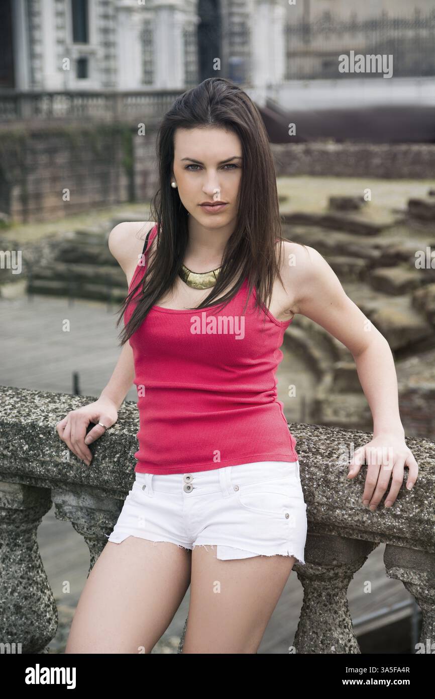 Attraktive junge Frau lehnt sich an steinernen Balustraden Stockfoto