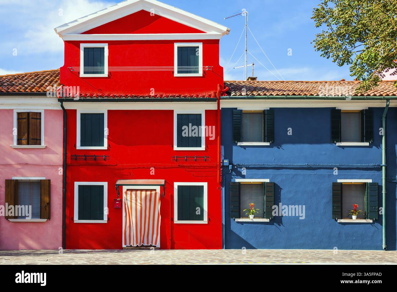 Die kleine malerische Insel Burano in der Nähe von Venedig. Fassade eines hübschen rot-blauen Hauses. Das Konzept der kulturellen, historischen und Fototouri Stockfoto