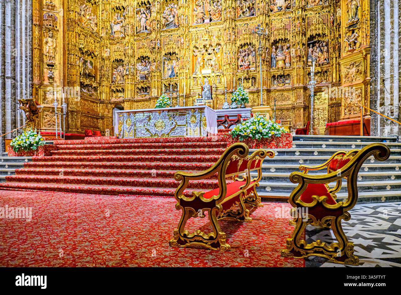 Zwei luxuriöse antike Bänke in der Nähe des Hauptaltars, Innenausstattung in der Kathedrale von Sevilla. Stockfoto