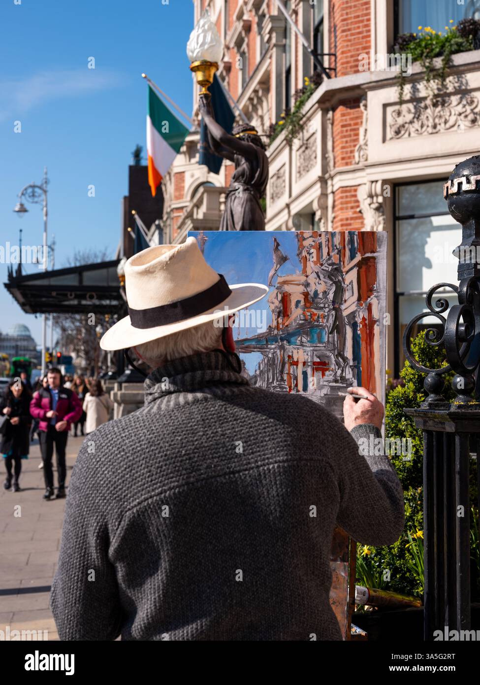 Ein Künstler auf der Straße malt das Merrion Hotel in Dublin, Irland. Stockfoto