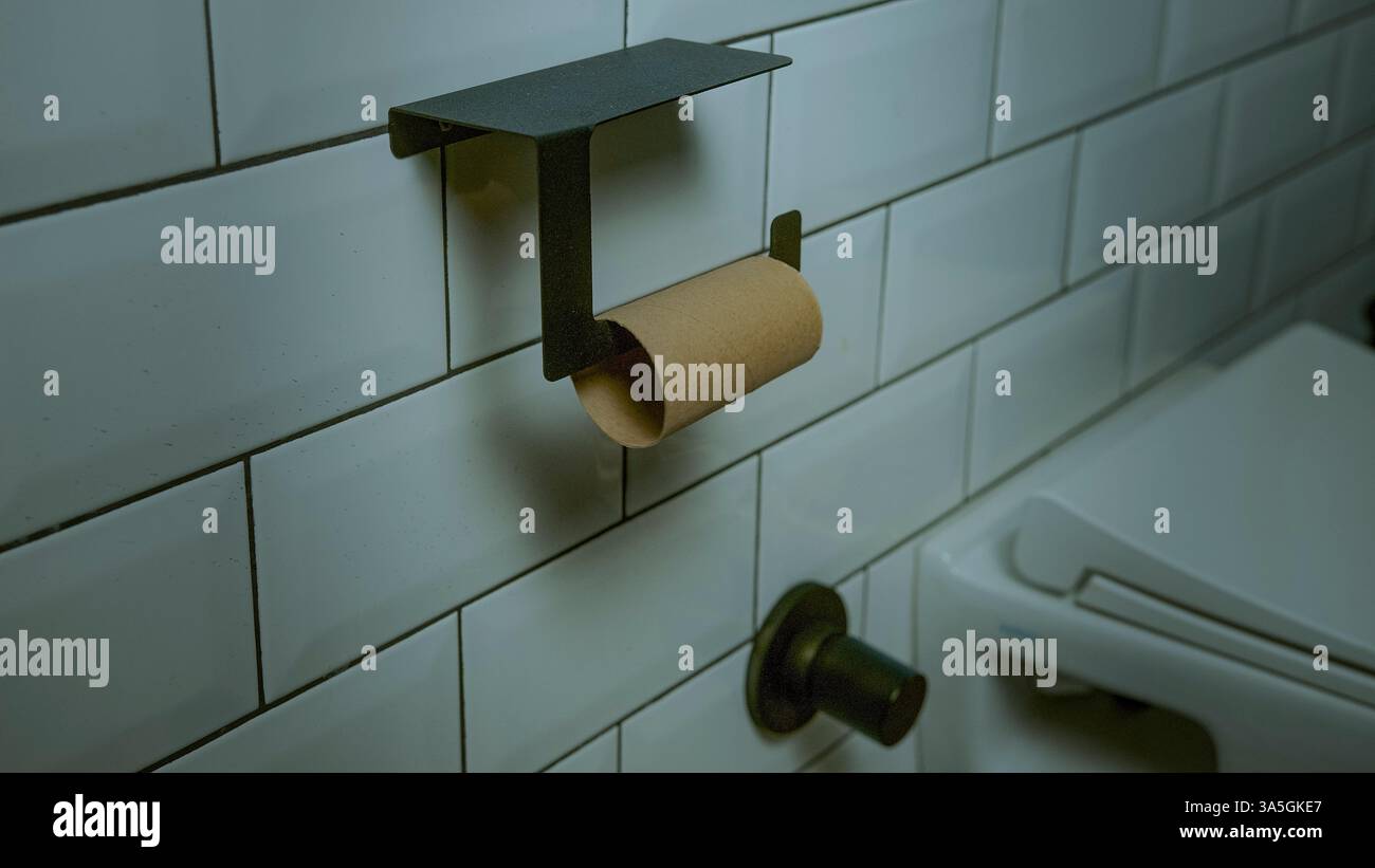 Toilettenpapier wird verwendet und wird abgenutzt, was Wirtschaft und Verbrauch symbolisiert Stockfoto