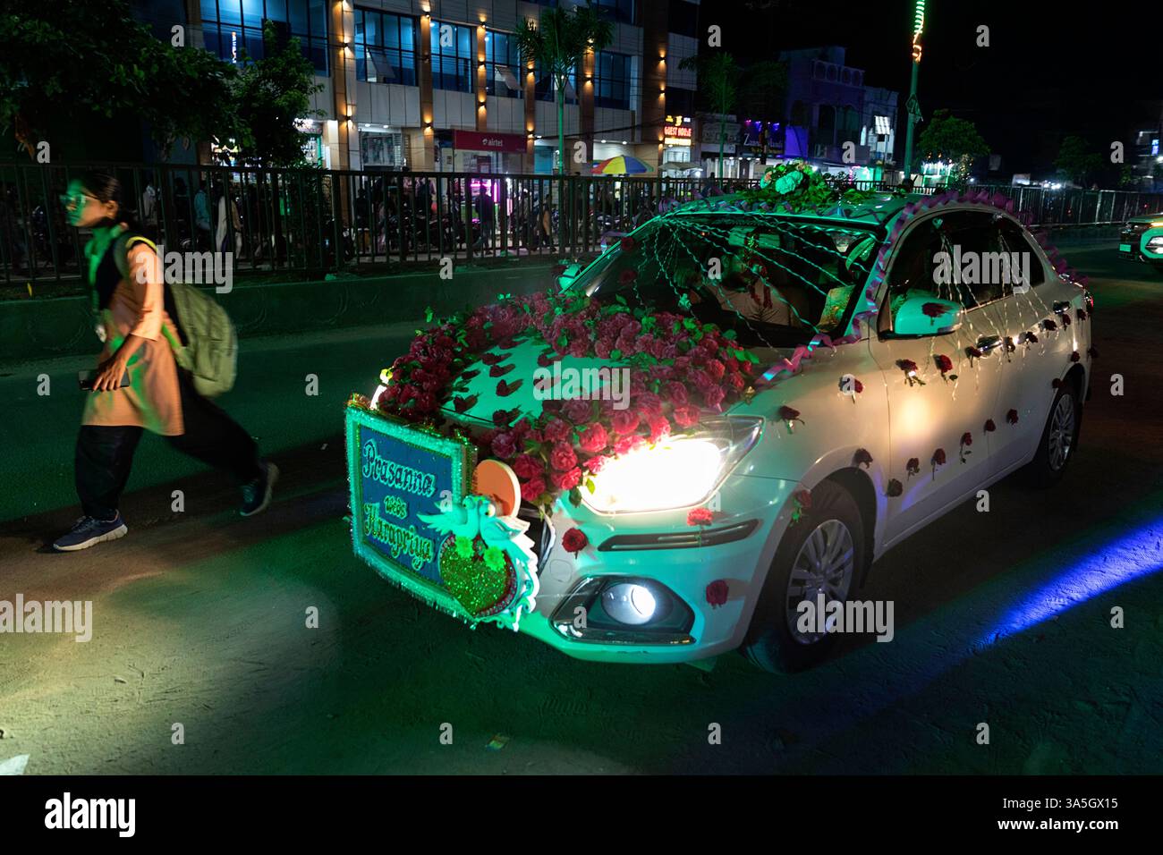 Dekoriertes Auto eines Bräutigams auf einer Straße in Schuss, traditionelle indische Hochzeit in einer Stadt, orissa, indien, Blumen auf einem weißen Auto eines Bräutigams Stockfoto