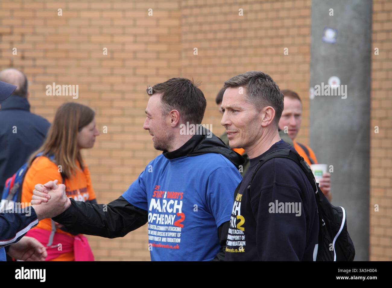 Colchester, Großbritannien. März 2025. März des Tages II inszeniert von der Darby Rimmer MND Foundation Spenden und Bewusstsein für Motoneurone Disease (MND). Die ehemaligen Profi-Fußballer Marcus Stewart und Stephen Darby, die beide über MND verfügen, haben dieses Jahr die Veranstaltung organisiert, die Fußballplätze mit einer Entfernung von 178 Meilen besucht. Die Wanderer kommen an und fahren vom Jwatch Community Stadium ab. Der ehemalige Spieler von Ipswich Town, Matt Holland, nimmt an der Tour Teil. Quelle: Eastern Views/Alamy Live News Stockfoto