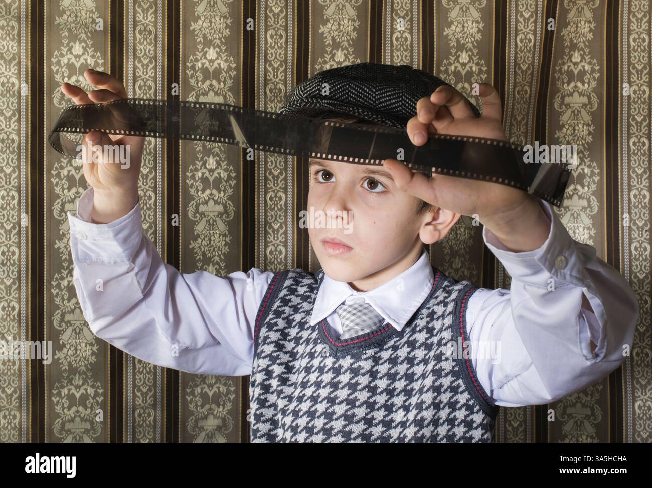 Kind als analogen Fotofilm. Vintage-Kleidung und Hintergrund Stockfoto