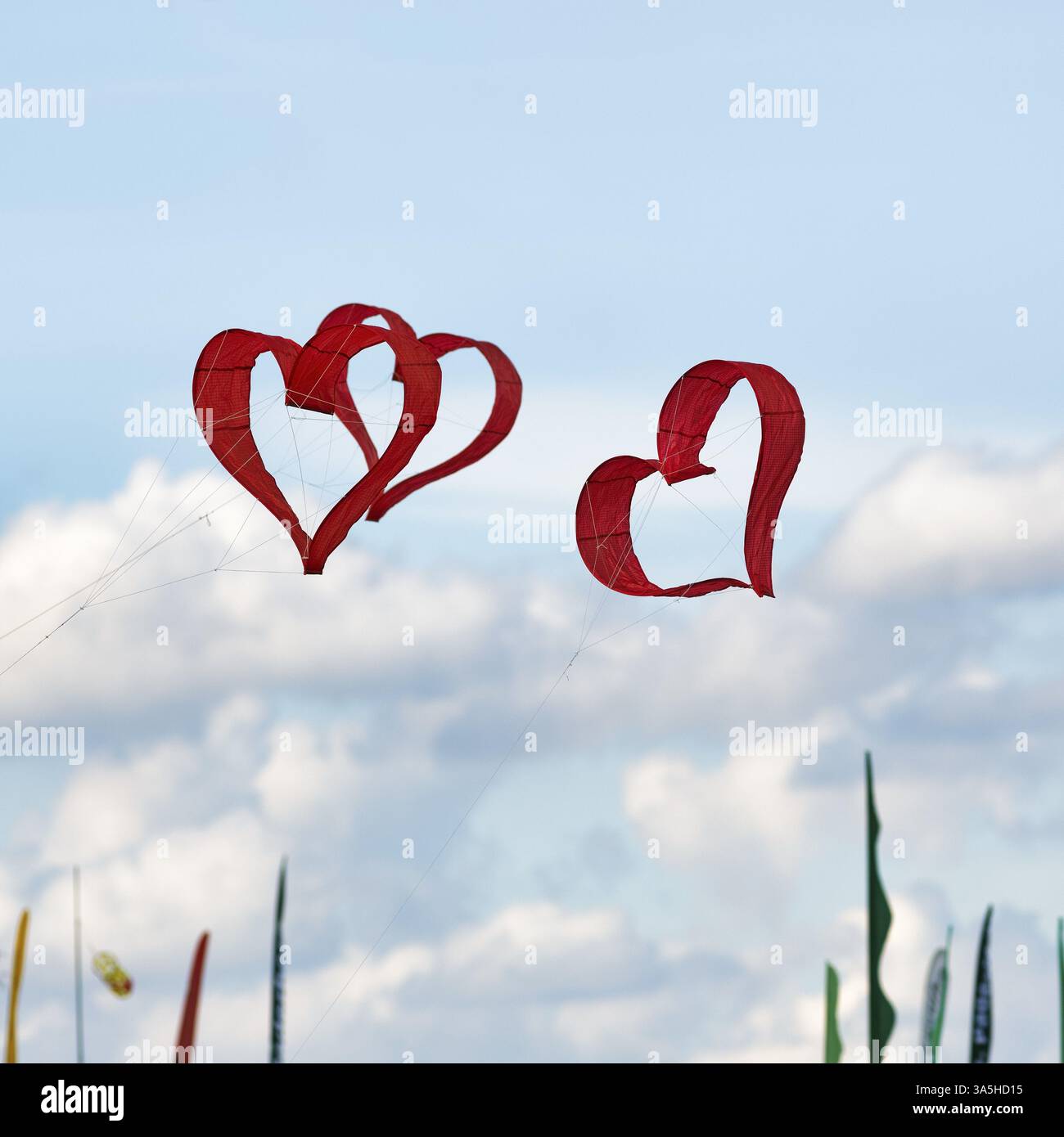 Drei rote herzförmige Drachen fliegen am Himmel, Text Free Space, Drachenfestival in Vinsebeck, Steinheim, Naturpark Eggegebirge und südliches Teut Stockfoto