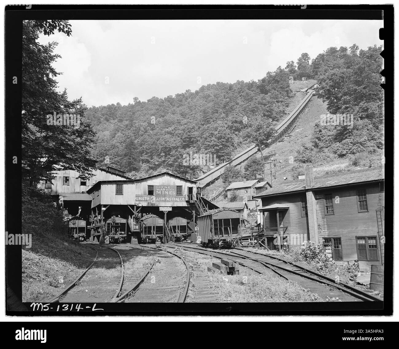 Der Ladetipple, die Kohlewagen und der Firmenspeicher in der Warwick Mine der Kingston Pocahontas Coal Company in Welch, McDowell County, West Virginia, sind ein wichtiger Bestandteil des Bergbaubetriebs und der Unterstützung der Arbeiter. Stockfoto