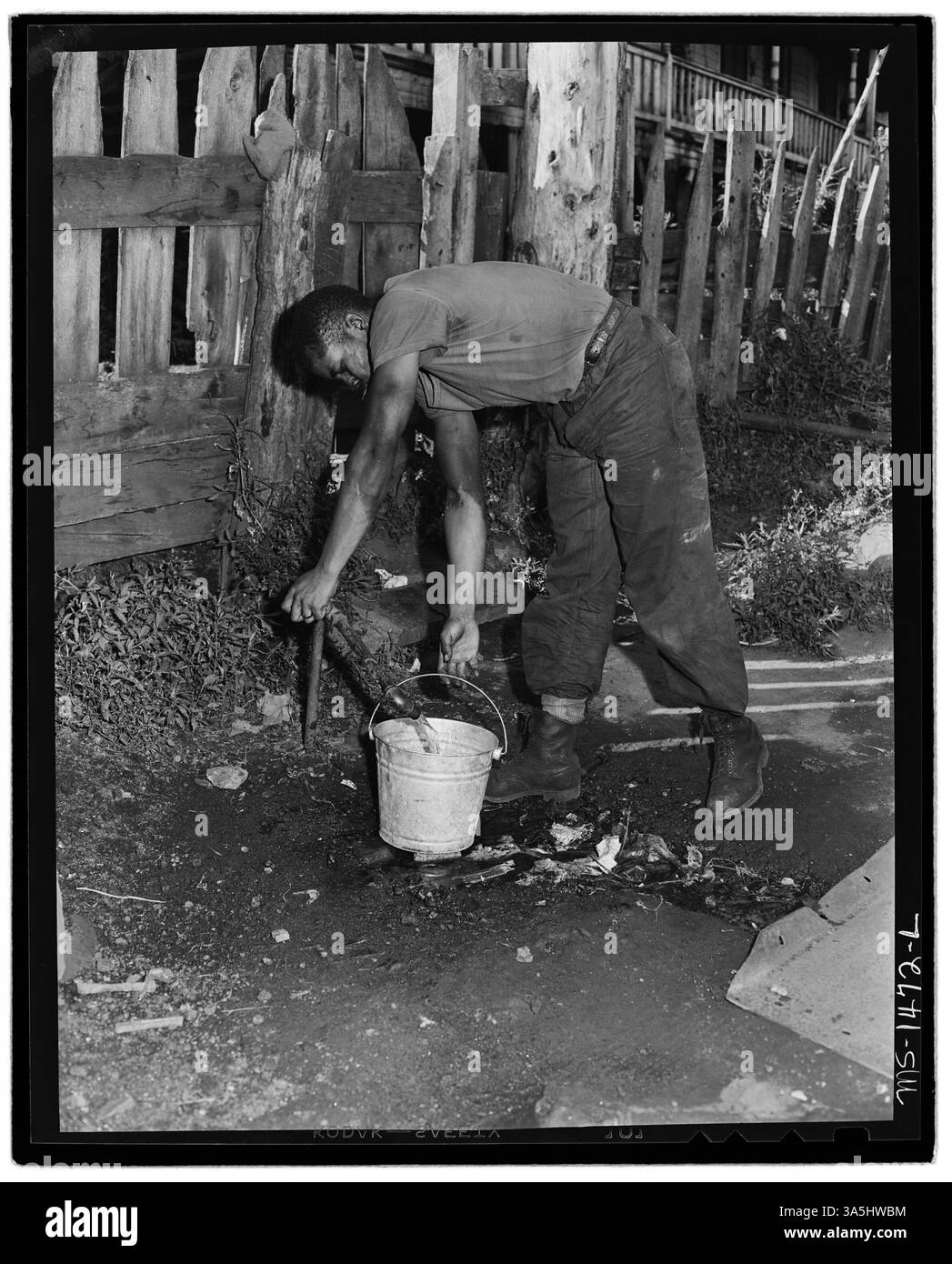 Ein Bergmann holt Wasser aus einem Wasserhahn vor seinem Haus in Gilliam, McDowell County, West Virginia, in der Nähe der Gilliam Coal and Coke Company. Stockfoto