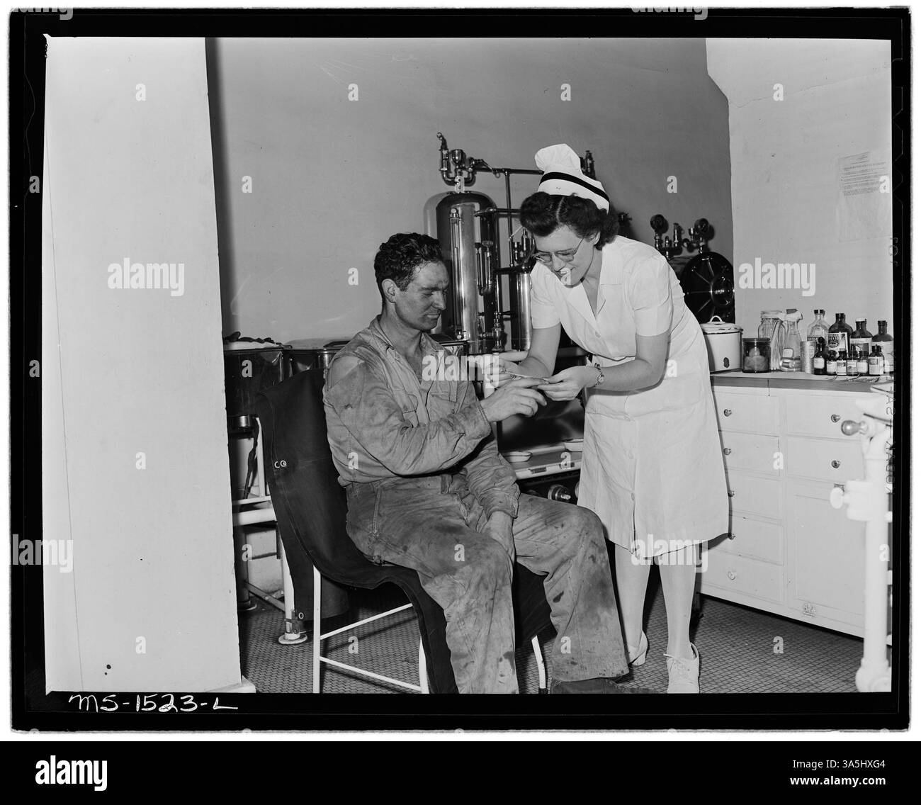 Die registrierte Krankenschwester Frau Eva Ruth Gray wird mit einem Patienten im OP des Gary Hospital, einem Teil der Gary Mines der US Coal and Coke Company in McDowell County, West Virginia, gesehen. Das Krankenhaus umfasst neben dem OP drei Behandlungsräume. Dieses Bild ist im Nationalarchiv erhalten. Stockfoto