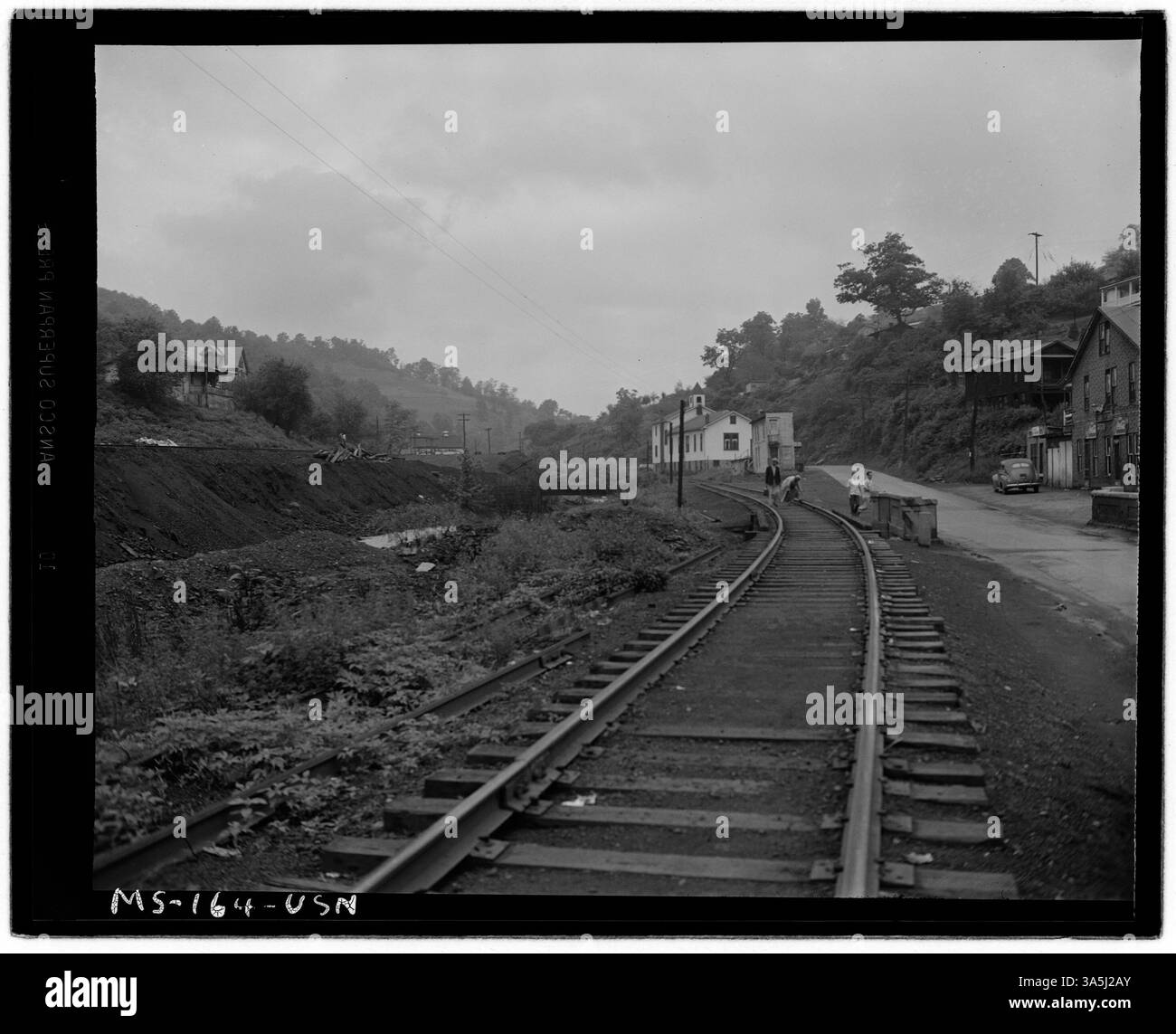 Ein Blick auf Eisenbahngleise, die durch eine Stadt führen, was wahrscheinlich den industriellen Einfluss auf die Infrastruktur der Gemeinde in den 1940er Jahren widerspiegelt Stockfoto