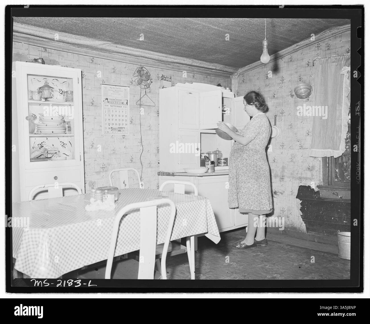 Mrs. Floyd Miller, Frau eines Bergarbeiters, steht in der Küche des Dreizimmerhauses ihrer Familie in Blanche, Bell County, Kentucky. Die Familie zahlt $6 monatlich für Miete und $3 für Strom. Nationalarchiv im College Park. Stockfoto