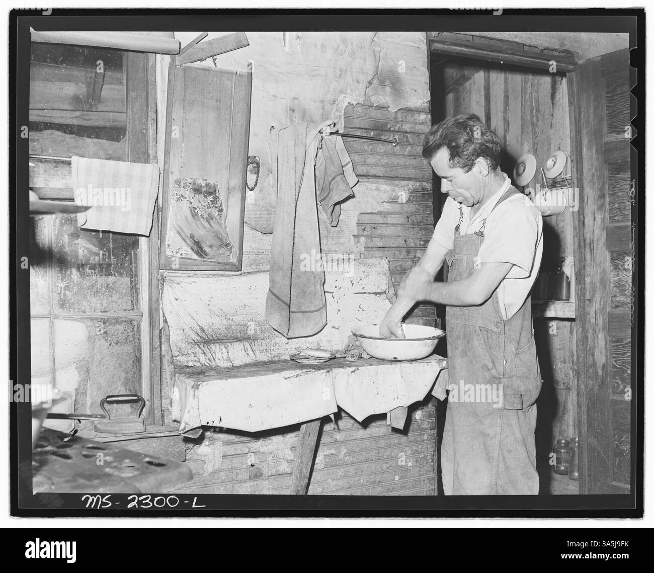 Oliver Hinkle, ein behinderter Bergarbeiter, wäscht sich die Hände in der Küche seines Hauses in Four Mile, Bell County, Kentucky. Die Belva Mine, betrieben von der Kentucky Straight Creek Coal Company, wurde nach einer Explosion im Dezember 1945 aufgegeben. Stockfoto Oliver Hinkle, ein behinderter Bergarbeiter, wäscht sich die Hände in der Küche seines Hauses in Four Mile, Bell County, Kentucky. Die Belva Mine, betrieben von der Kentucky Straight Creek Coal Company, wurde nach einer Explosion im Dezember 1945 aufgegeben. Stockfoto