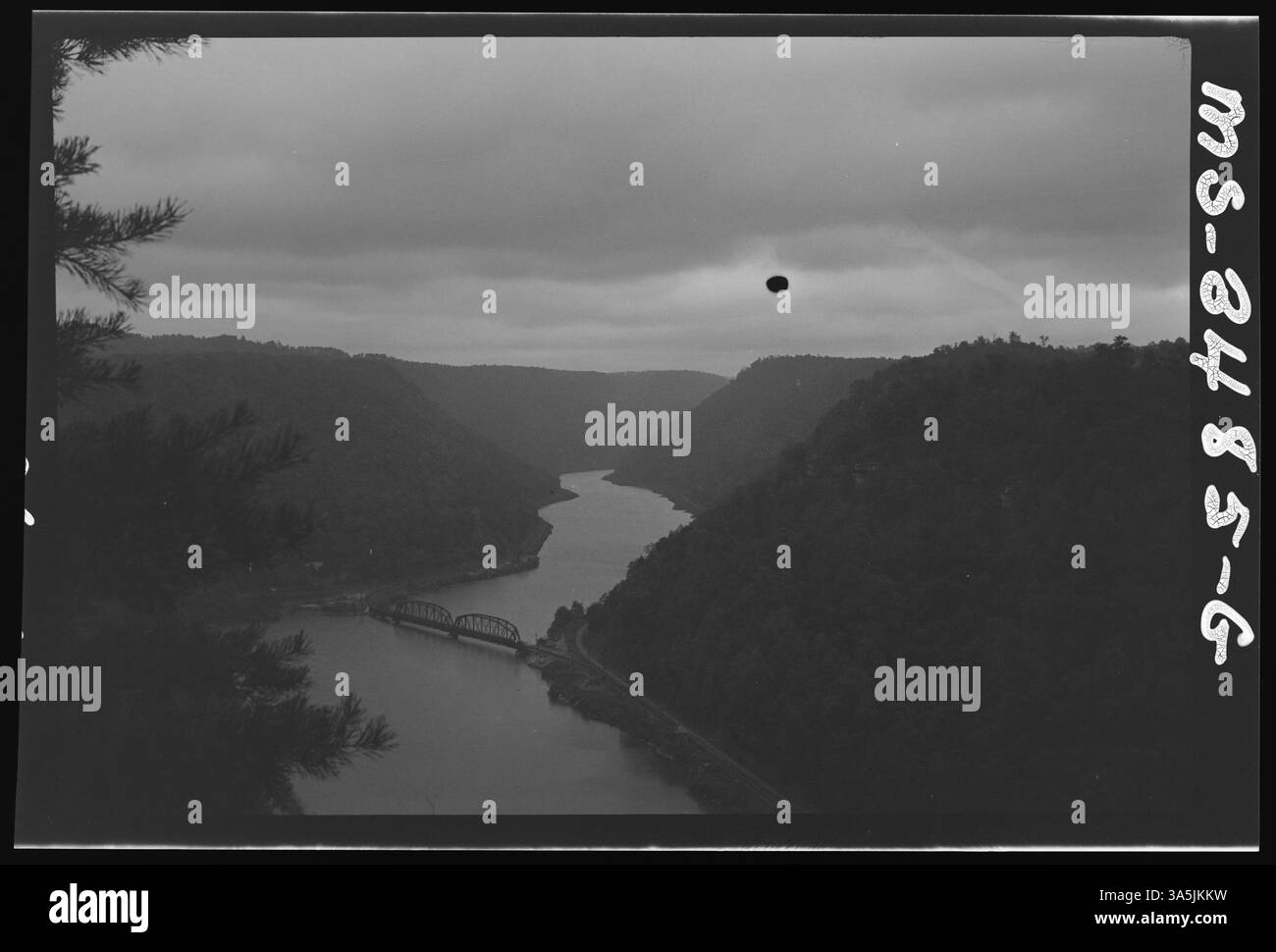 Dieses Foto aus dem Jahr 1946 zeigt einen malerischen Blick auf ein Flusstal und eine angrenzende Brücke. Das Bild zeigt die natürliche Landschaft und Infrastruktur in der Region. Stockfoto