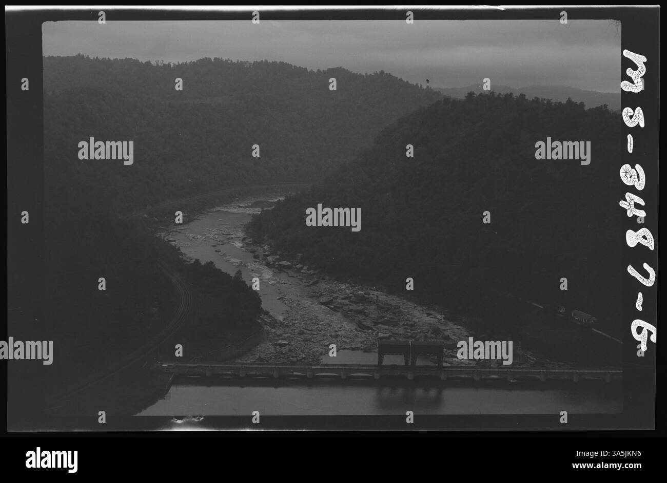 Ein Foto aus dem Jahr 1946 von einem Flusstal mit einer begleitenden Brücke, das die Kombination von natürlicher Schönheit und menschlicher Infrastruktur in der Region veranschaulicht. Stockfoto