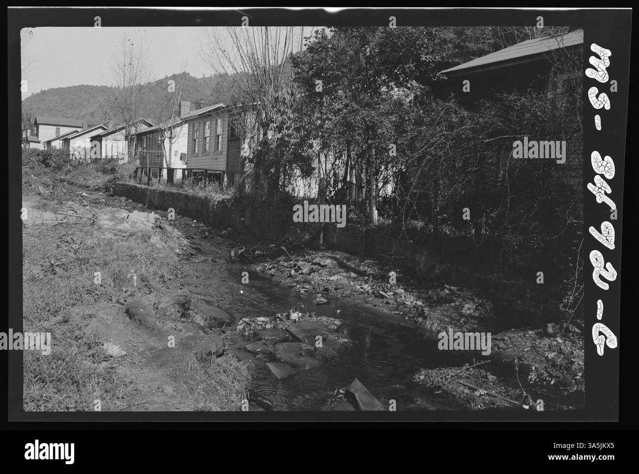 Ein Bach fließt durch das Firmengrundstück der Helen Mines der Koppers Coal Division im Raleigh County, West Virginia, wodurch die Interaktion zwischen den Bergbaubetrieben und den lokalen Wasserstraßen hervorgehoben wird. Stockfoto