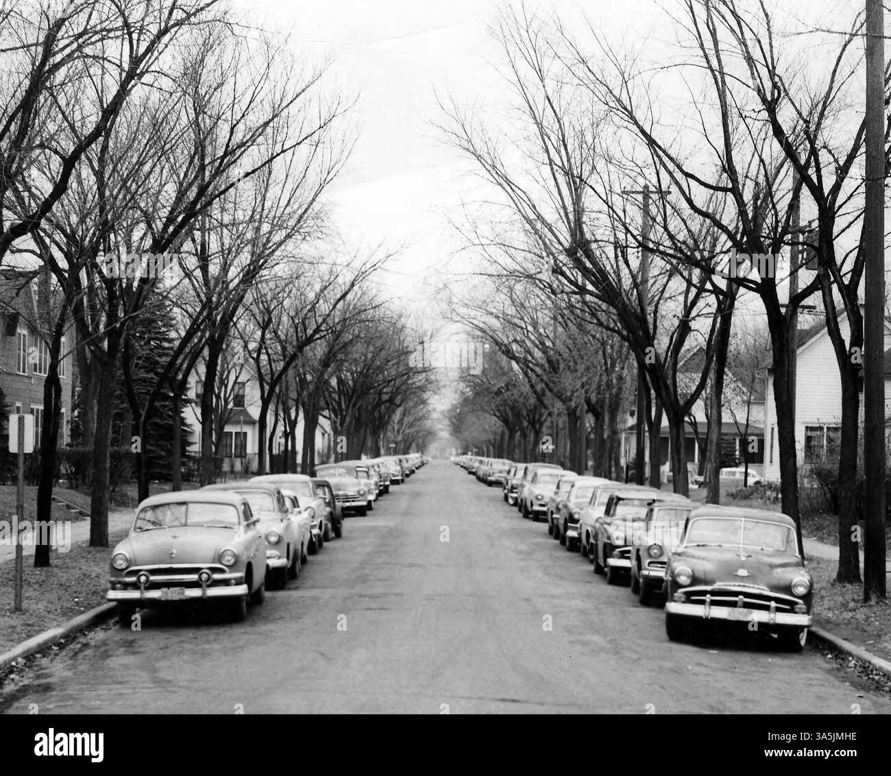 Autos, die auf einer Straße in der Nähe des Campus der St. Cloud State University geparkt sind, zeigen die nahe gelegenen öffentlichen Verkehrsmittel und Möglichkeiten für Studentenverkehr. Stockfoto