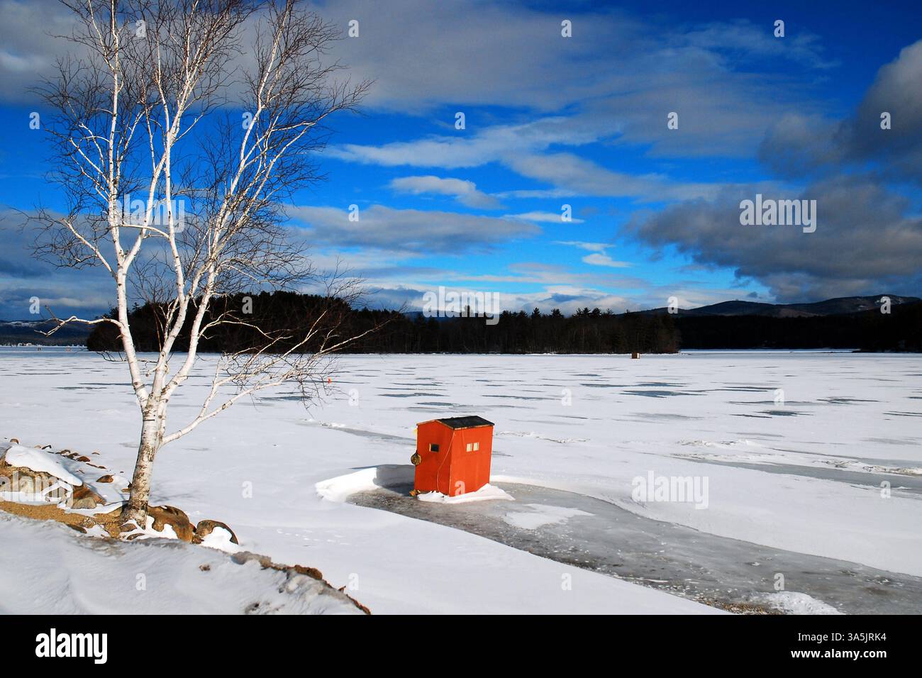 Eine einsame Eisfischerei steht auf einem gefrorenen See in Neuengland Stockfoto