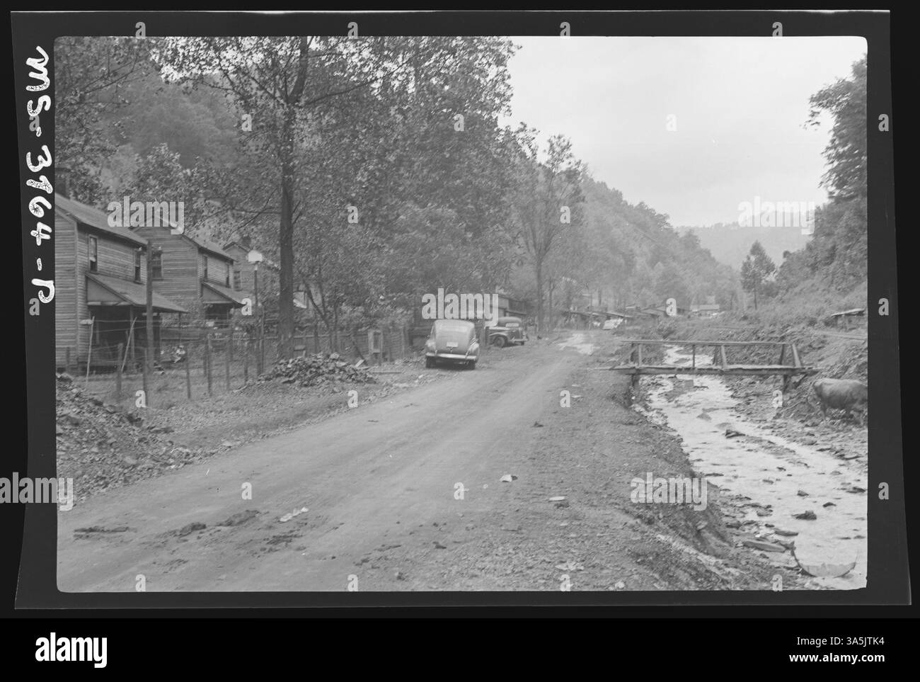Dieses Bild zeigt einen Bach, der durch das Minenlager Ames #2B der Ames Mining Company in Thacker, West Virginia verläuft, wo Müll und Abfall entsorgt wurden, was die schlechten Umweltbedingungen in Bergbaulagern veranschaulicht. Stockfoto
